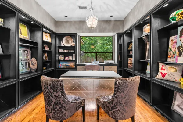 a view of a dining room with furniture a chandelier and window