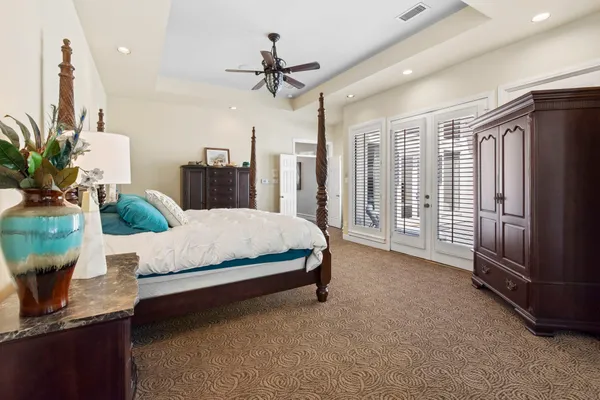 a spacious bedroom with a large bed and a chandelier