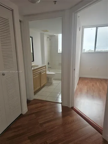 an empty room with wooden floor and mirror