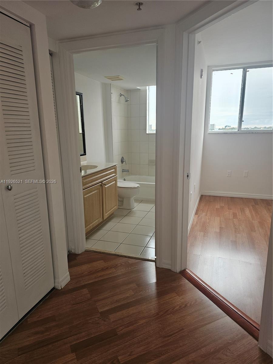 102 Southwest 6th Avenue, Unit 604 Miami, FL 33130 - Photo 13 of 13 an empty room with wooden floor and mirror