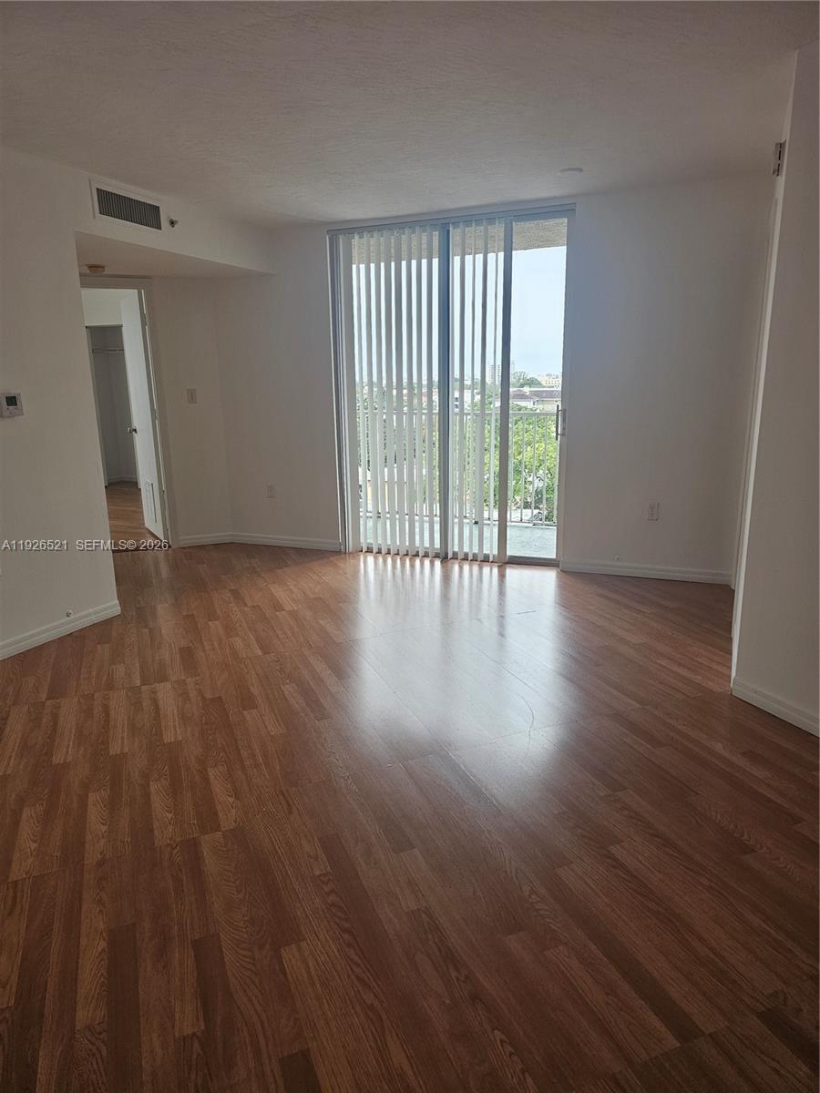 102 Southwest 6th Avenue, Unit 604 Miami, FL 33130 - Photo 7 of 13 a view of an empty room with wooden floor and a window
