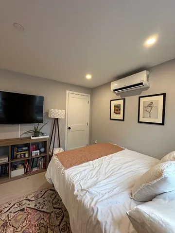 a bedroom with a large bed and a flat screen tv