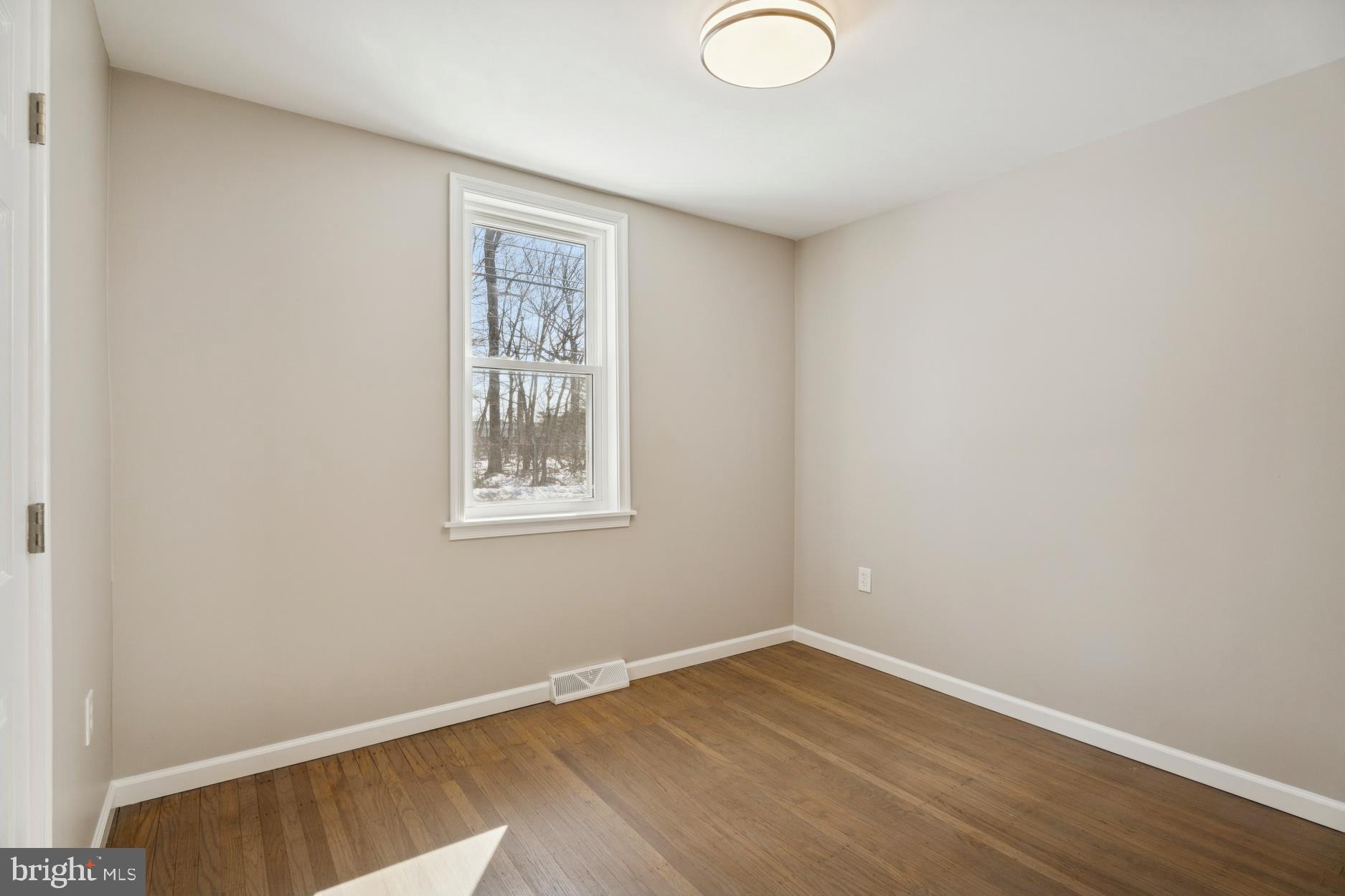 306 Grape Street Warminster, PA 18974 - Photo 12 of 25 a view of an empty room with wooden floor and a window