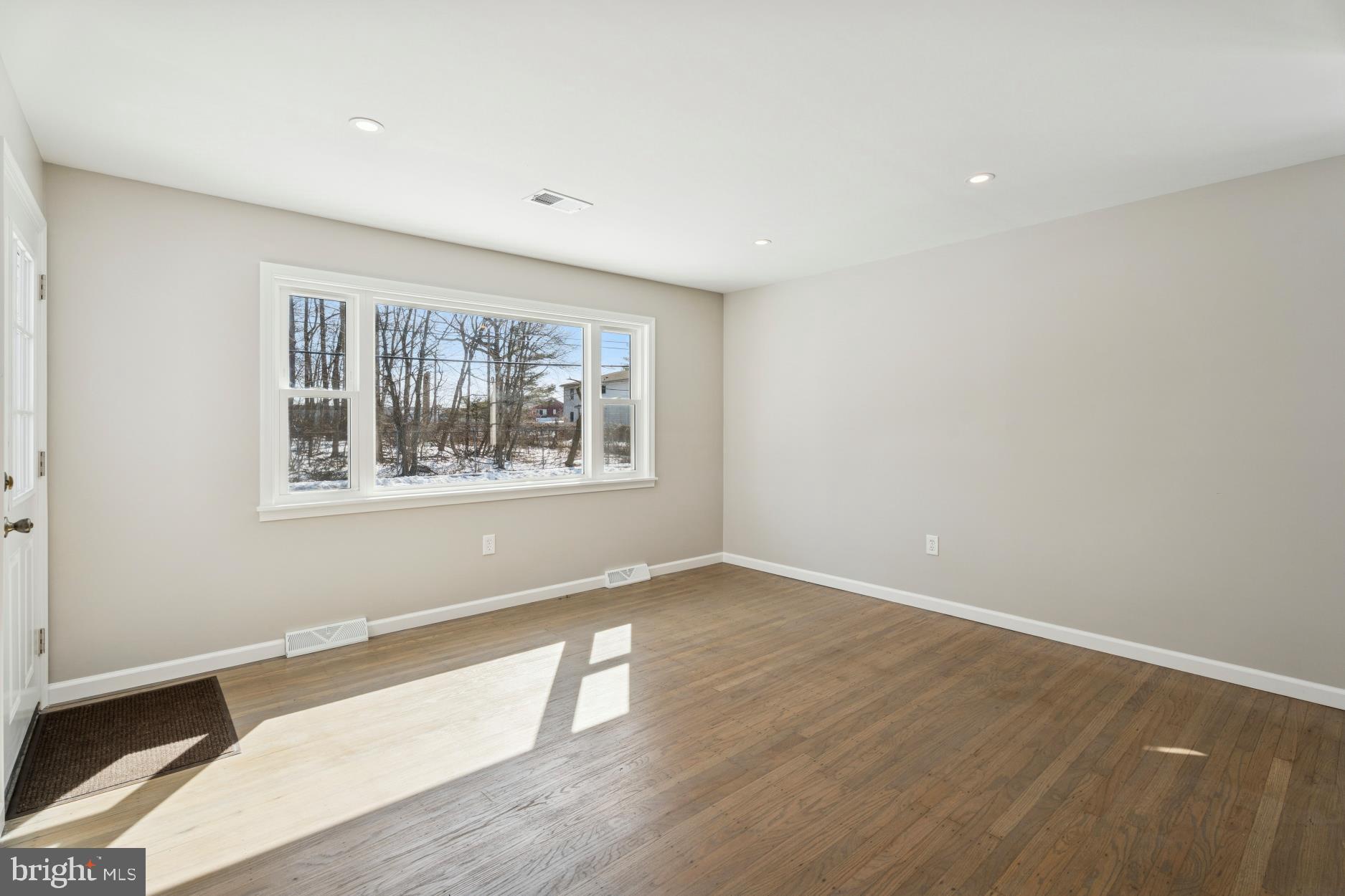 306 Grape Street Warminster, PA 18974 - Photo 5 of 25 an empty room with wooden floor and windows