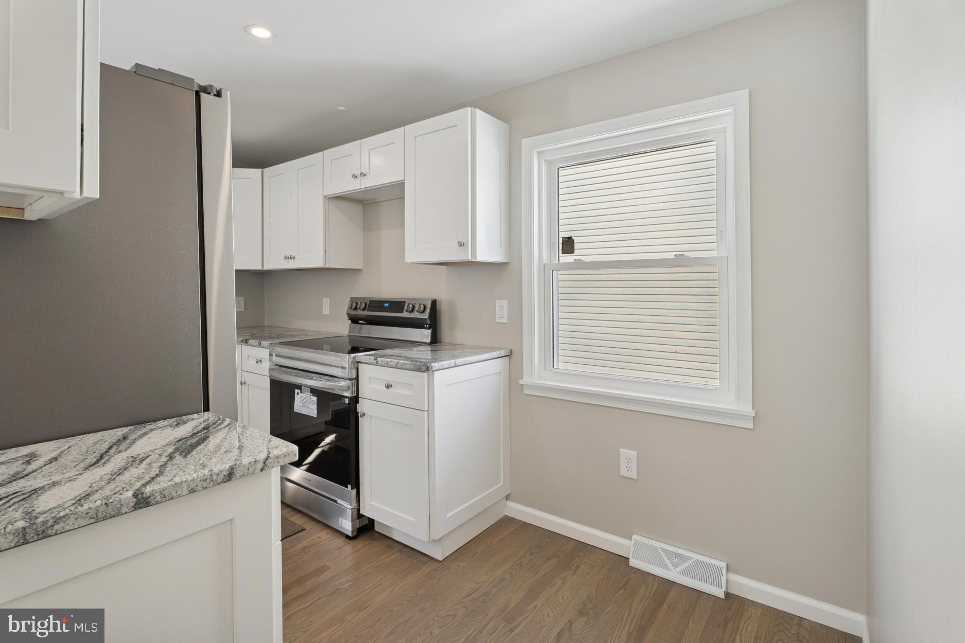 306 Grape Street Warminster, PA 18974 - Photo 10 of 25 a kitchen with granite countertop white cabinets and white appliances