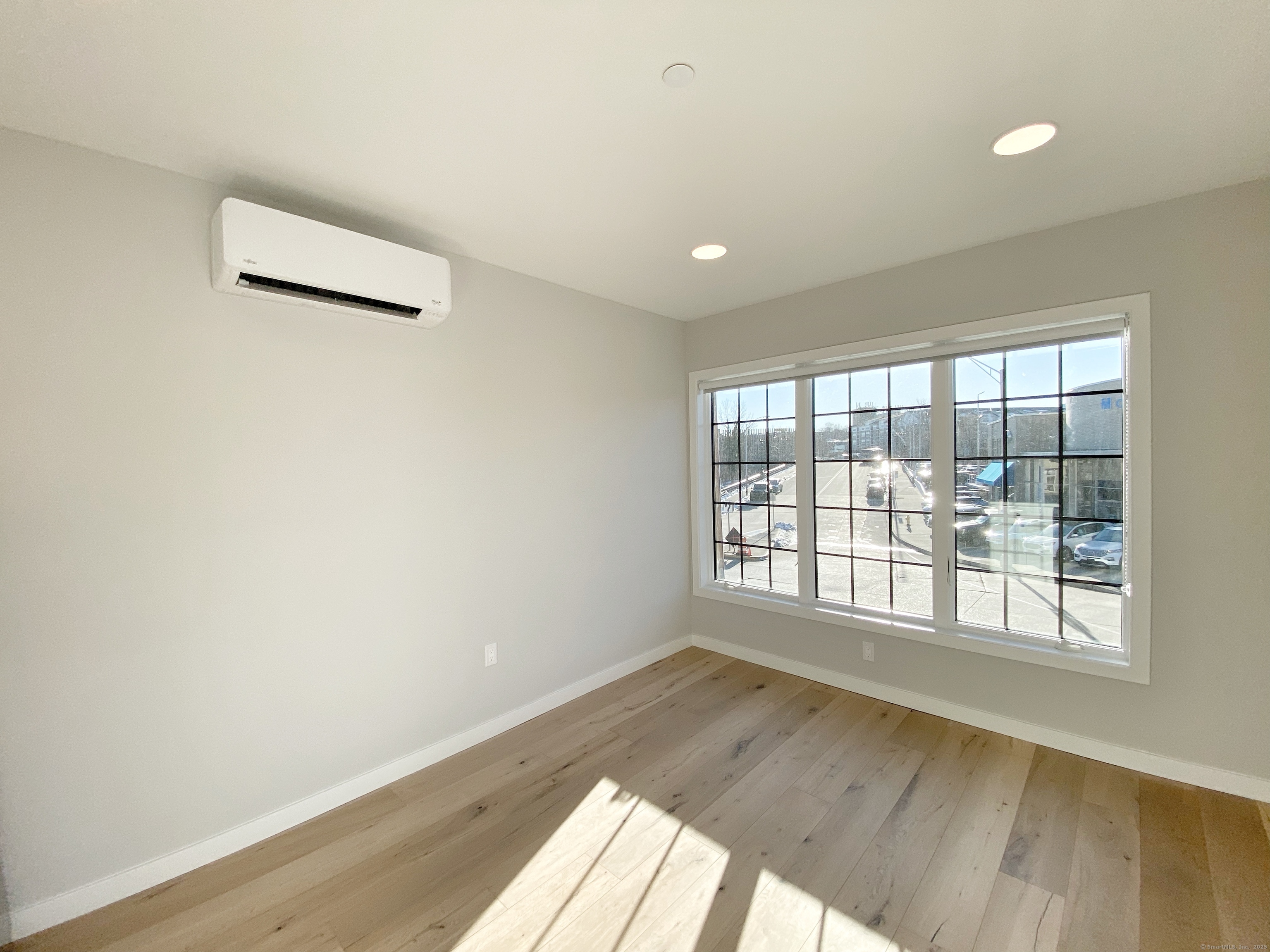 32 Main Street, Unit 207 Norwalk, CT 06851 - Photo 2 of 8 an empty room with wooden floor and windows