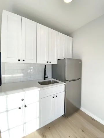 a kitchen with a refrigerator and cabinets