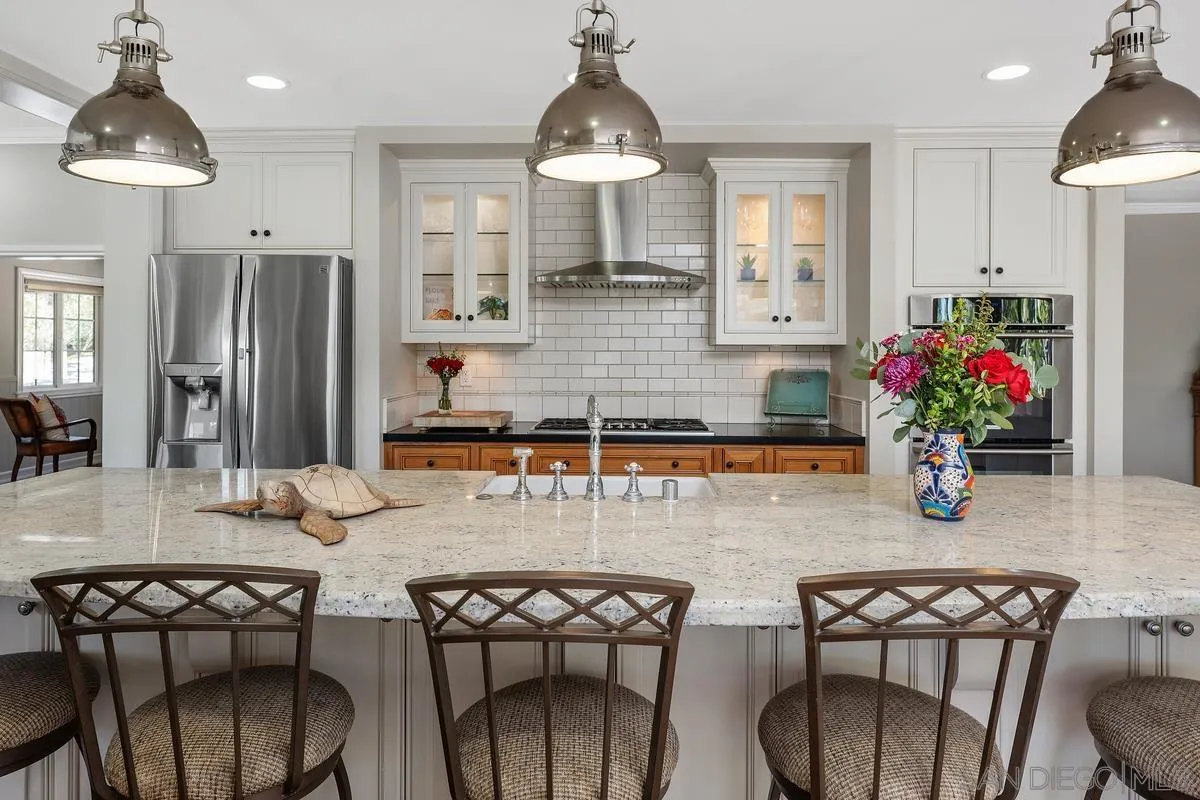 13627 Poway Springs Road Poway, CA 92064 - Photo 13 of 60 a kitchen with stainless steel appliances a dining table chairs and granite counter tops