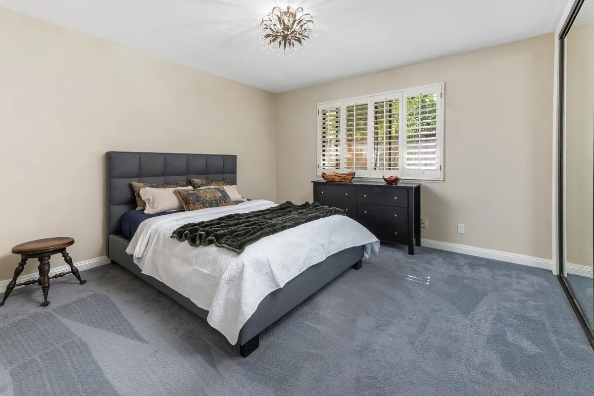 13627 Poway Springs Road Poway, CA 92064 - Photo 21 of 60 a bedroom with a bed and a chandelier