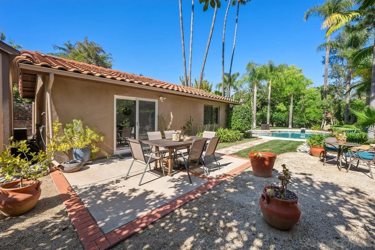13627 Poway Springs Road Poway, CA 92064 - Photo 43 of 60 a view of a patio with table and chairs potted plants and palm tree