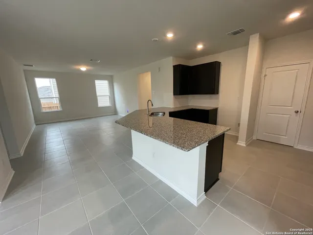 a large kitchen with kitchen island granite countertop stainless steel appliances and a sink