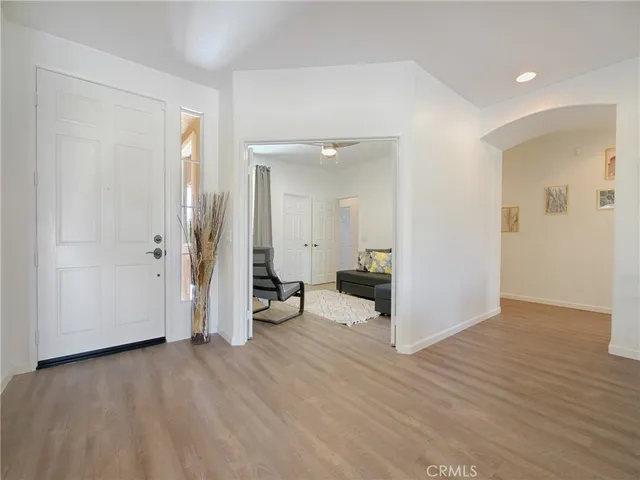 a view of a livingroom with wooden floor and a bathroom