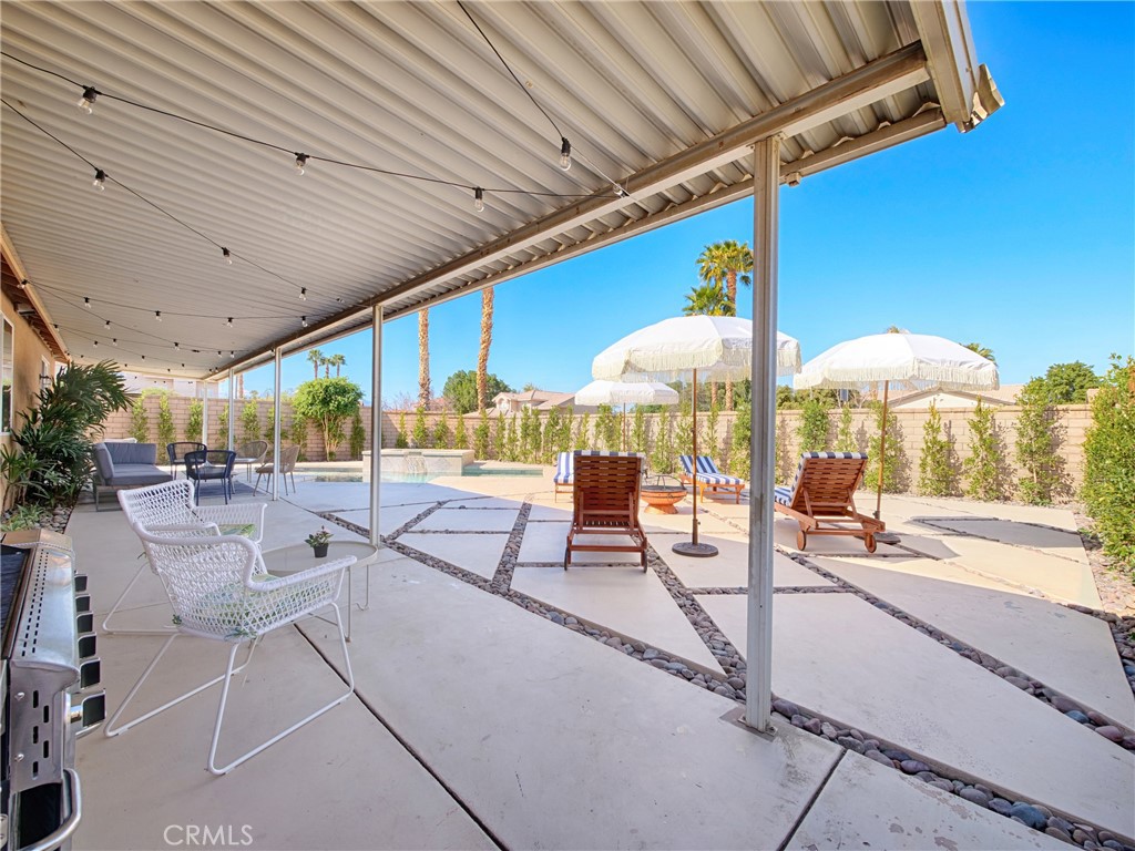80718 Mountain Mesa Drive Indio, CA 92201 - Photo 35 of 47 a outdoor space with lots of tables a large window and chairs