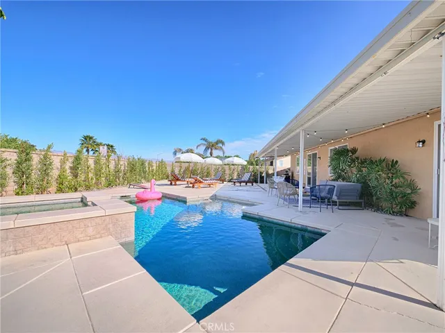 a view of a patio with dining table and chairs with a small yard