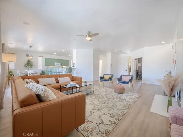 a living room with furniture kitchen view and a chandelier