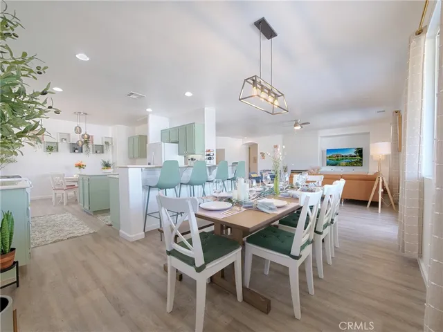 a dining room with furniture a chandelier and wooden floor
