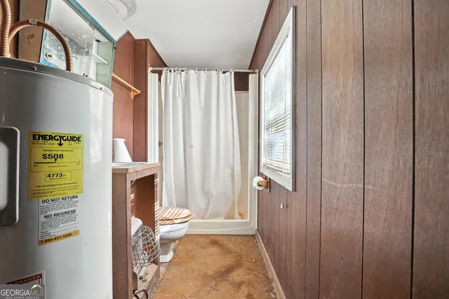 a bathroom with a toilet and a shower curtain