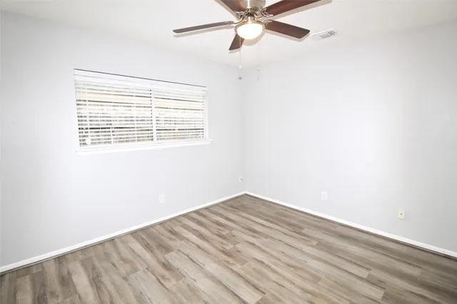 an empty room with a window and a fan