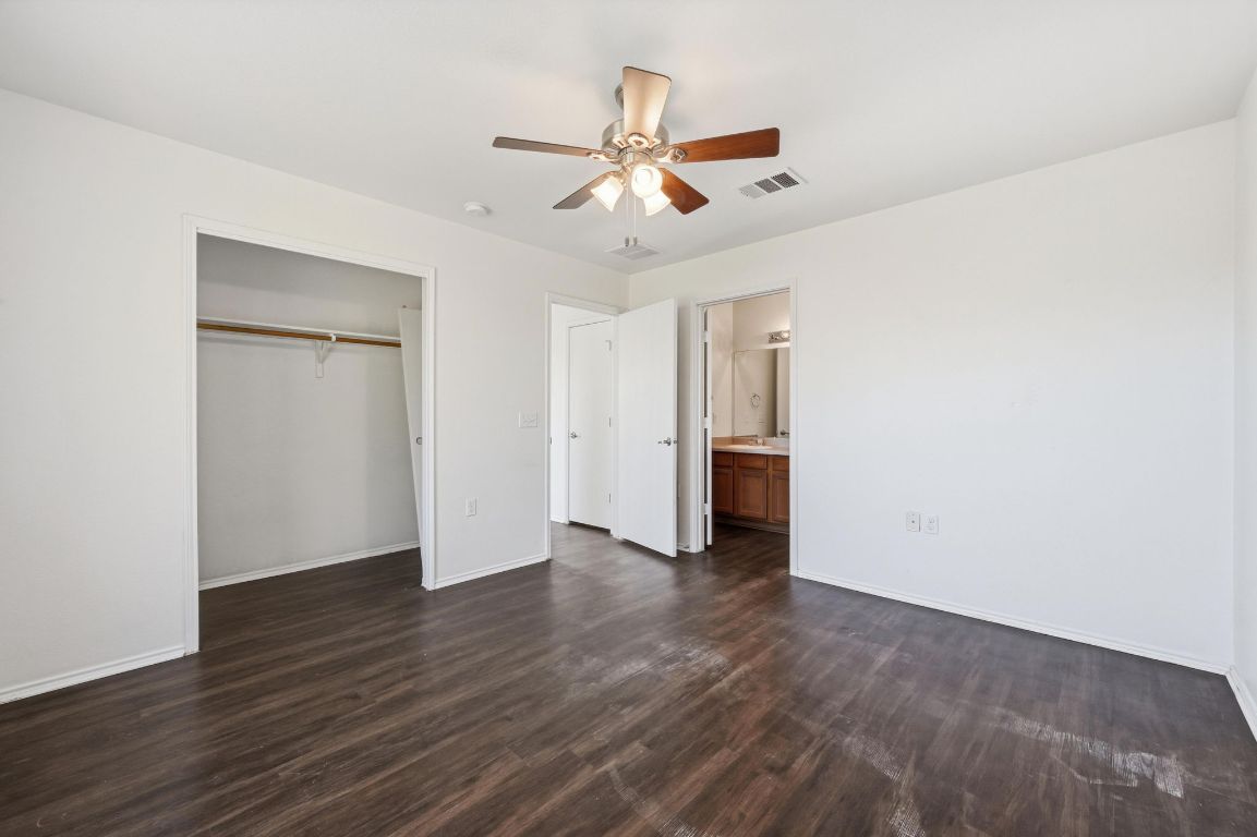 5813 Berryline Way Austin, TX 78724 - Photo 13 of 27 an empty room with wooden floor ceiling fan and windows