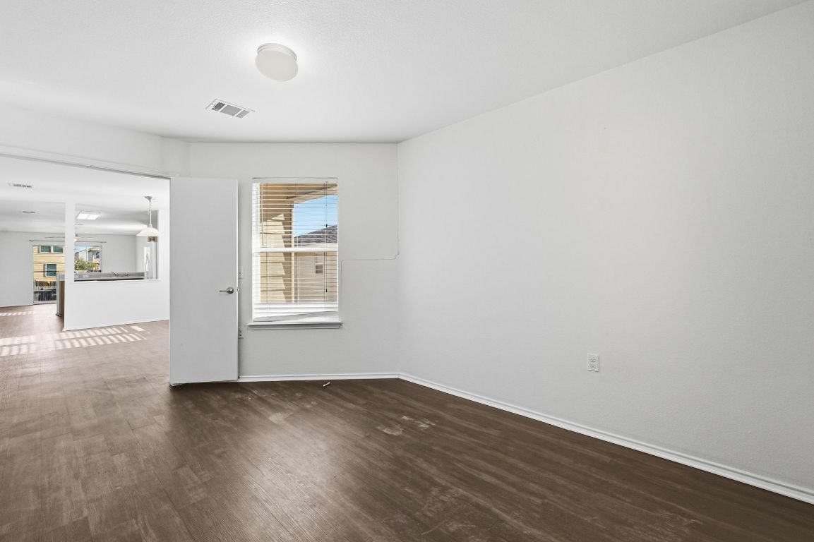 5813 Berryline Way Austin, TX 78724 - Photo 15 of 27 a view of an empty room with wooden floor and a window