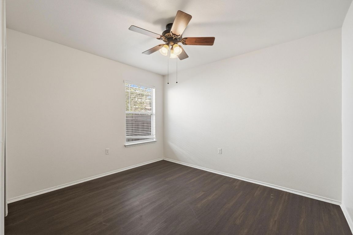 5813 Berryline Way Austin, TX 78724 - Photo 16 of 27 an empty room with wooden floor fan and windows
