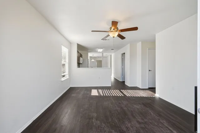 a view of a livingroom with wooden floor and a ceiling fan