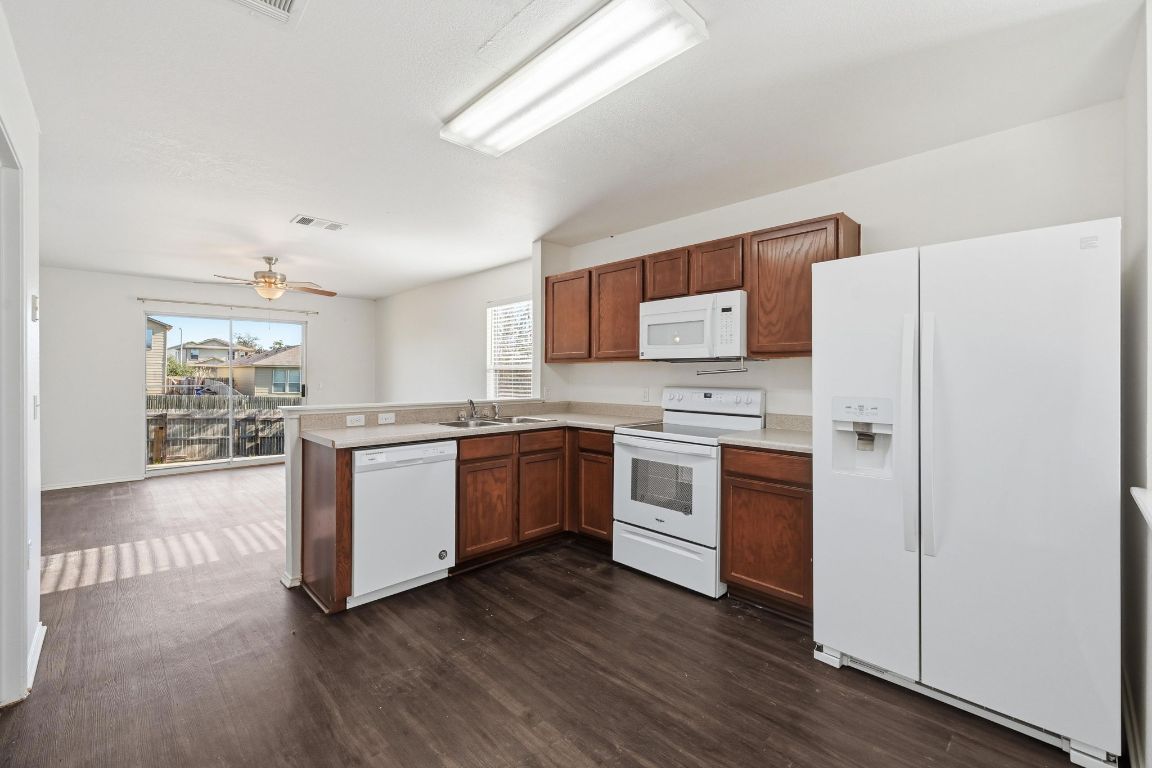 5813 Berryline Way Austin, TX 78724 - Photo 7 of 27 a kitchen with granite countertop a refrigerator stove top oven and sink
