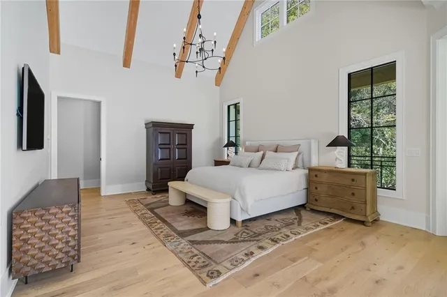 a spacious bedroom with a bed and large windows