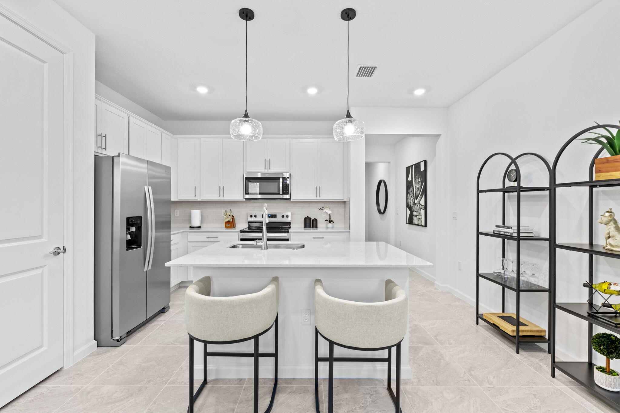 395 Southwest Sally Way Stuart, FL 34997 - Photo 8 of 12 a kitchen with stainless steel appliances granite countertop a table chairs refrigerator and sink