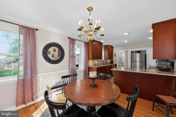 a view of a dining room with furniture a chandelier and wooden floor