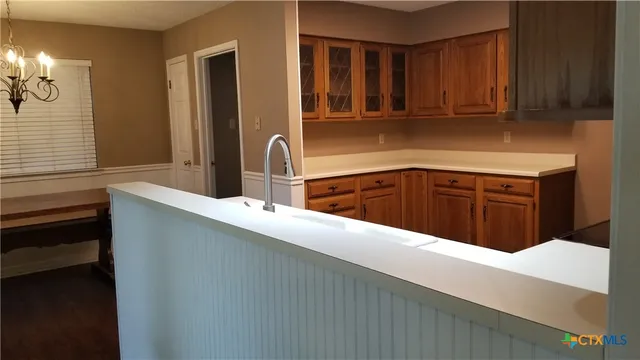 a kitchen with stainless steel appliances a sink dishwasher a stove a refrigerator with wooden cabinets