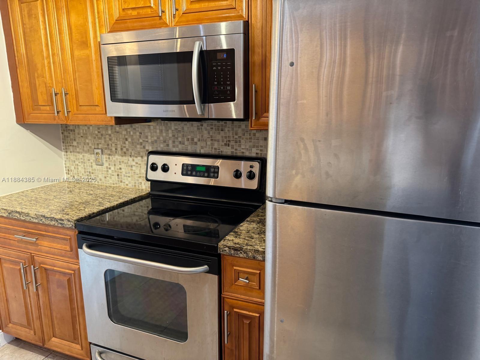 2471 Southwest 82nd Avenue, Unit 108 Davie, FL 33324 - Photo 3 of 14 a kitchen with a stove microwave and refrigerator