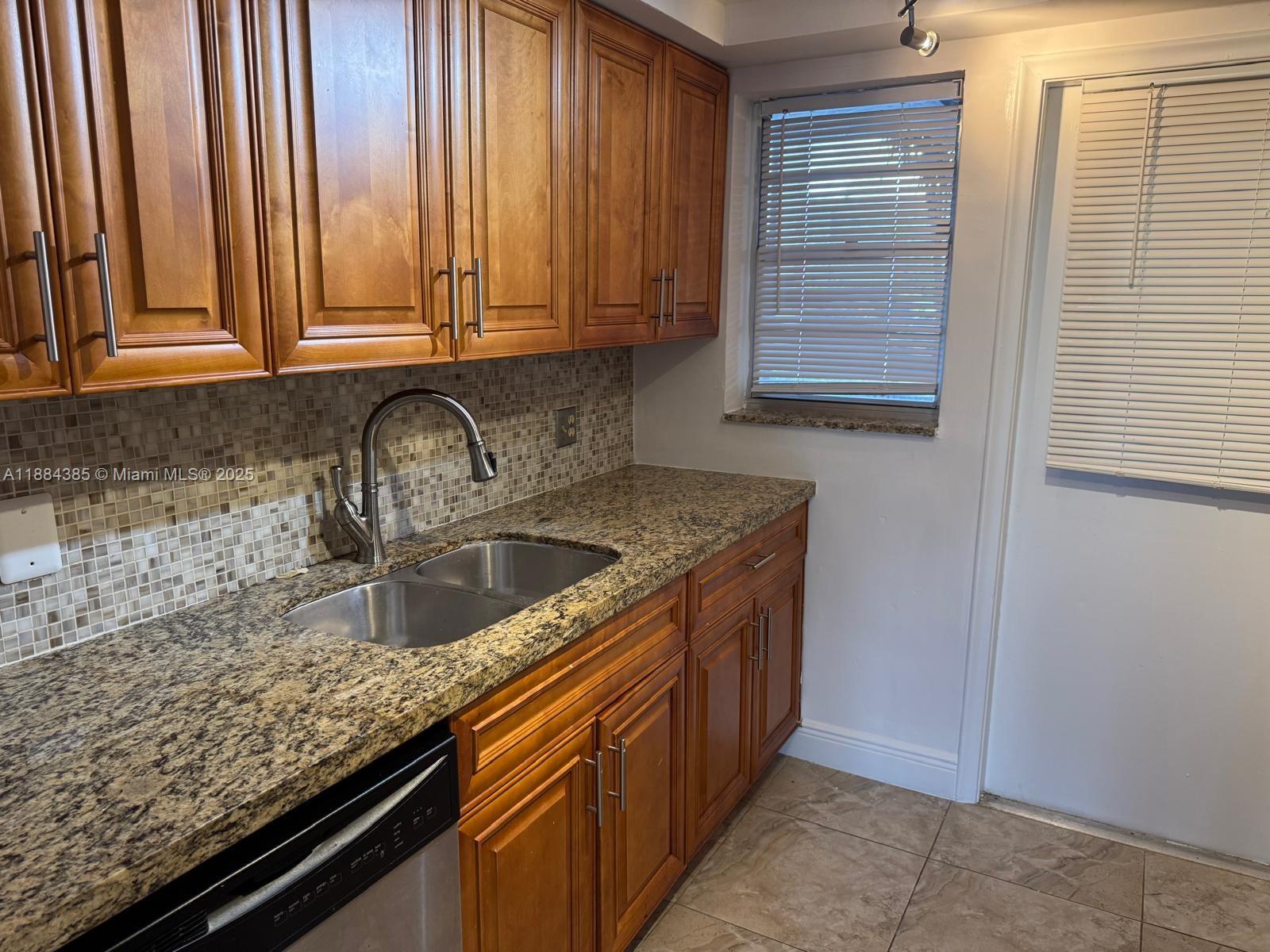 2471 Southwest 82nd Avenue, Unit 108 Davie, FL 33324 - Photo 4 of 14 a kitchen with granite countertop a sink and cabinets