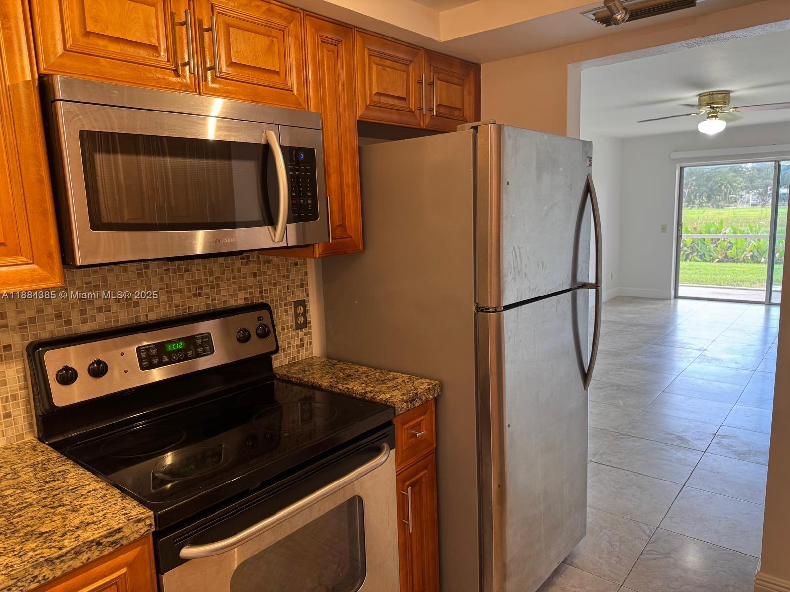 2471 Southwest 82nd Avenue, Unit 108 Davie, FL 33324 - Photo 5 of 14 a kitchen with stainless steel appliances a stove a microwave and a refrigerator