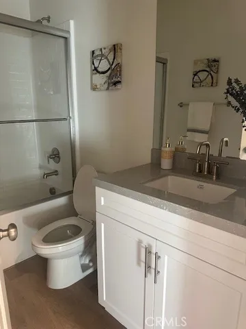 a bathroom with a granite countertop toilet sink and mirror