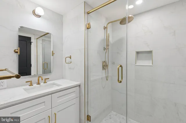 a bathroom with a shower sink vanity and mirror