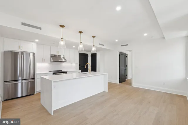 a kitchen with stainless steel appliances a refrigerator sink and microwave