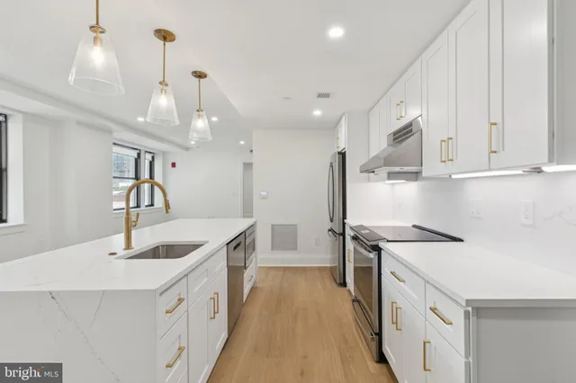 a kitchen with a sink a stove a refrigerator and cabinets