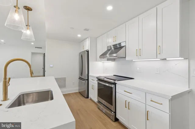 a kitchen with white cabinets and stainless steel appliances