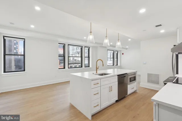 a kitchen with stainless steel appliances granite countertop a sink and a stove top oven