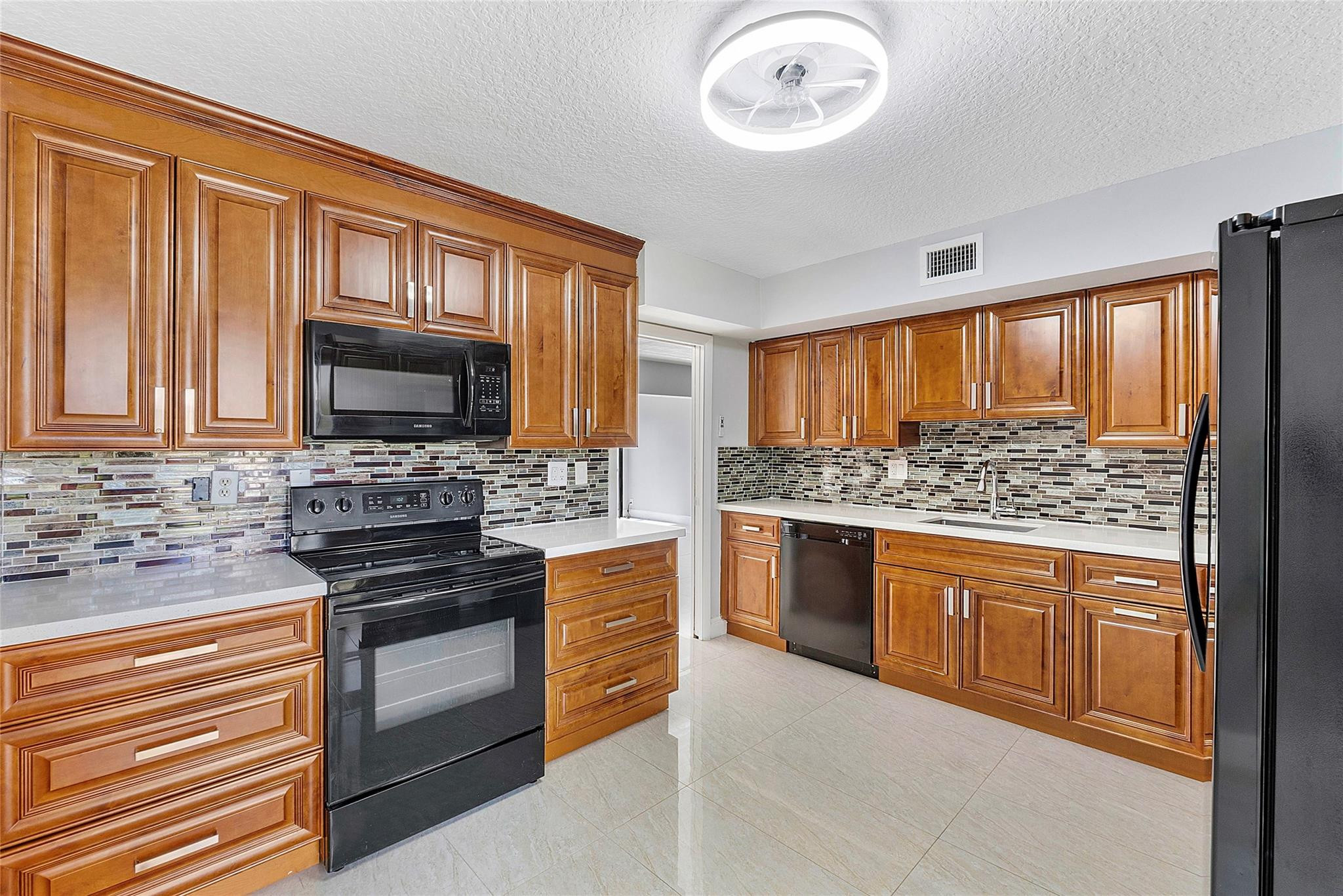 6593 Spring Bottom Way, Unit 237 Boca Raton, FL 33433 - Photo 19 of 49 a kitchen with stainless steel appliances granite countertop a stove top oven microwave and cabinets