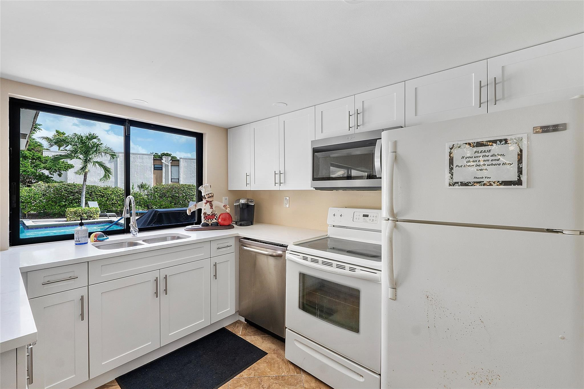 6593 Spring Bottom Way, Unit 237 Boca Raton, FL 33433 - Photo 46 of 49 a kitchen with white cabinets and white appliances