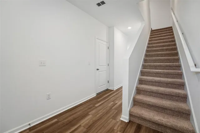 a view of a hallway with wooden floor and entryway