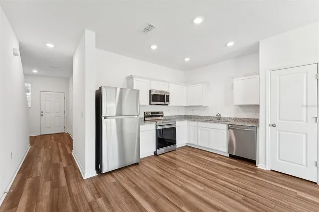 a view of a kitchen with wooden floor and a window