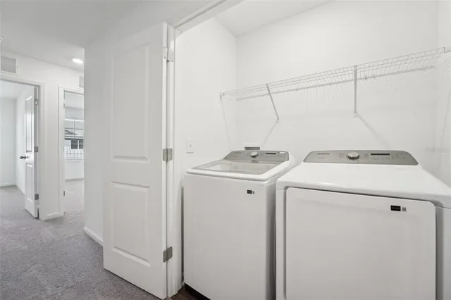 a view of kitchen and empty room with wooden floor