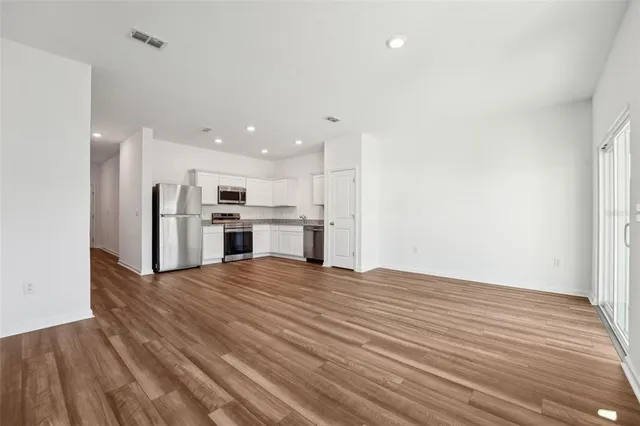 a view of kitchen with wooden floor and electronic appliances