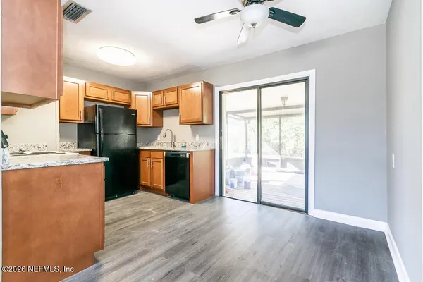 a kitchen with stainless steel appliances granite countertop a refrigerator a sink dishwasher and a stove with wooden floor