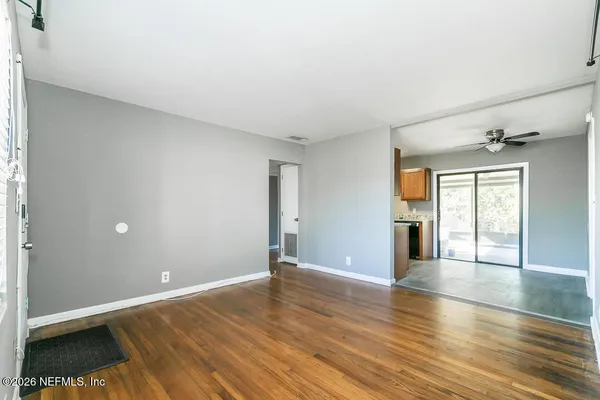 a view of an empty room with wooden floor