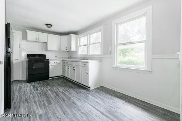 a kitchen with wooden floors and white appliances
