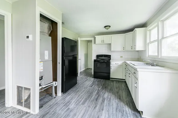 a kitchen with a refrigerator a sink and dishwasher with wooden floor